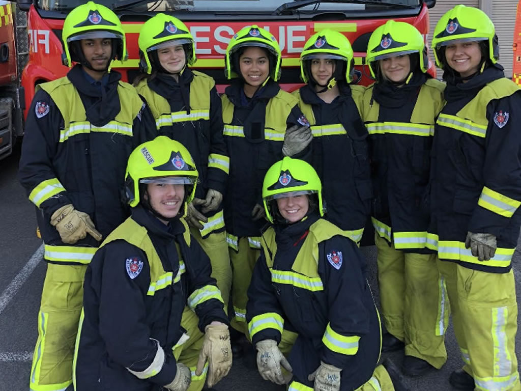 Photo of a group of students enjoying work experience dressed in firefighting gear.